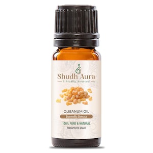 May include: A brown glass bottle of Shudh Aura Olibanum Oil. The label reads "100% Pure & Natural Therapeutic Grade." The bottle has a black cap and contains amber-colored liquid. The label also features the text "Ethically Sourced."