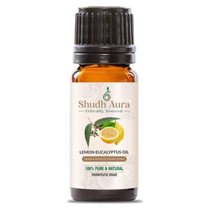May include: A brown glass bottle with a black cap, labeled "Shudh Aura - Ethically Sourced" and "Lemon Eucalyptus Oil". The label also includes the text "Eucalyptus citriodora syn Corymbia citriodora", "100% Pure & Natural", and "Therapeutic Grade". The bottle is decorated with a green leaf and a yellow lemon.