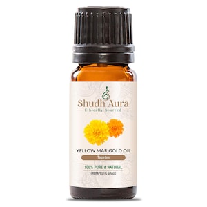 May include: A small amber glass bottle of Yellow Marigold Oil. The label features the text "Shudh Aura" and "Ethically Sourced". Below the logo are two yellow marigold flowers. The text "100% Pure & Natural" and "Therapeutic Grade" are also visible.