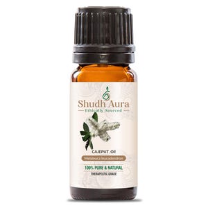 May include: A brown glass bottle with a black cap, labeled "Shudh Aura Ethically Sourced" and "CAJEPUT Oil Melaleuca leucadendron 100% PURE & NATURAL THERAPEUTIC GRADE".