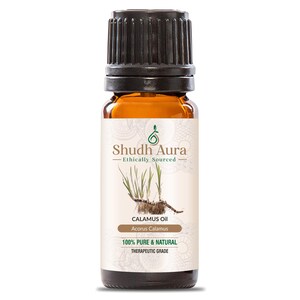 May include: A brown glass bottle with a black cap, labeled "Shudh Aura Ethically Sourced CALAMUS Oil Acorus Calamus 100% PURE & NATURAL THERAPEUTIC GRADE".