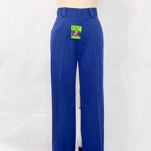 May include: A pair of vibrant blue pants with a high waist and wide legs. The pants have a classic design with a folded hem and a tag that reads "Knit". The pants are displayed on a mannequin.