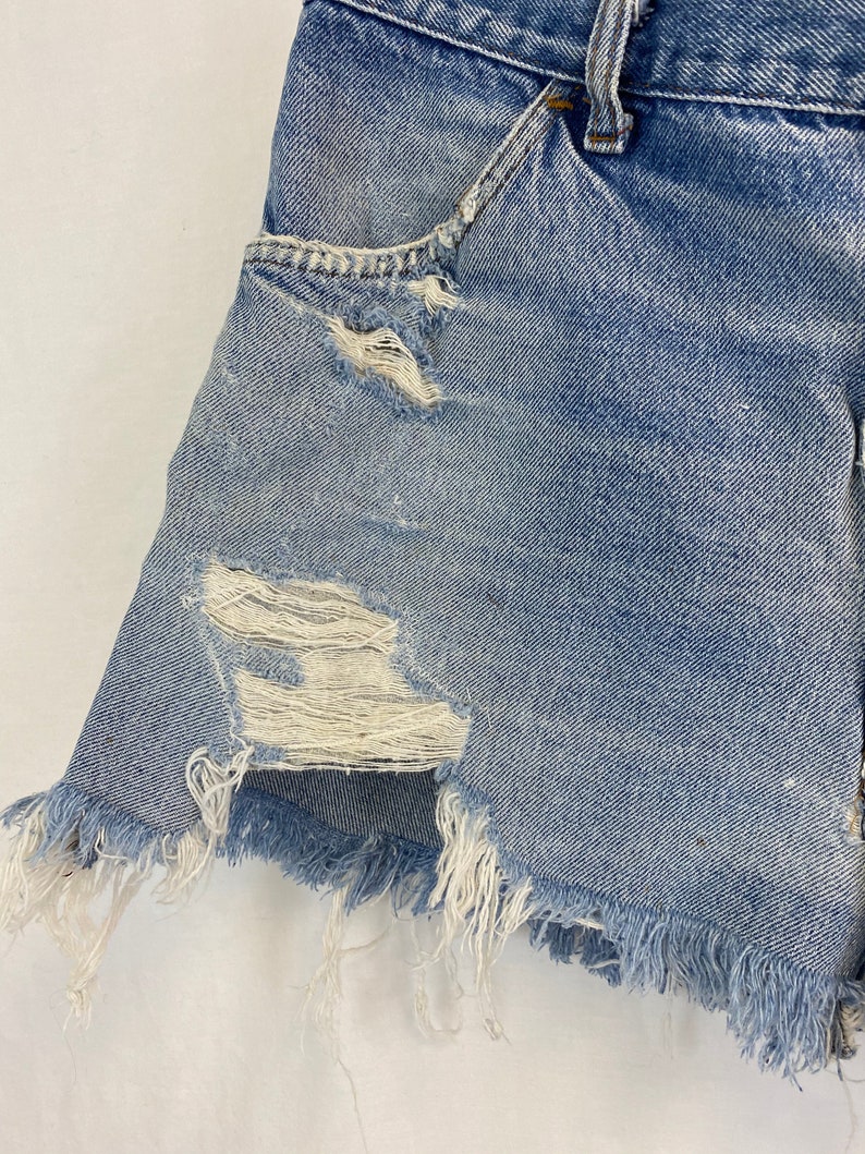 Pu&ograve; includere: Shorts di jeans blu chiaro con bordi sfrangiati e dettagli usurati. I pantaloncini hanno un lavaggio chiaro e sono realizzati in un tessuto morbido e confortevole.