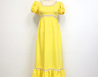 Könnte beinhalten: Ein langes gelbes Maxikleid mit einer weißen Spitzenborte am Ausschnitt und Saum. Das Kleid hat kurze Puffärmel und ein tailliertes Oberteil.