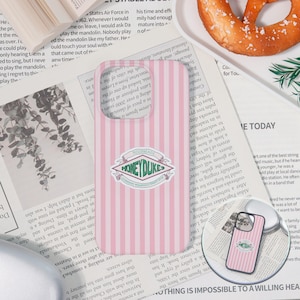 May include: A pink and white vertically striped phone case featuring a central emblem with the text Honeydukes, Hogsmeade, and Legendary Wizarding Sweets Shop. The design includes a green banner and decorative scrollwork on a light background.