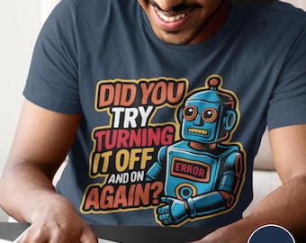 May include: A navy blue t-shirt featuring a graphic of a blue robot with orange accents. The text reads: DID YOU TRY TURNING IT OFF AND ON AGAIN? The robot has a red rectangular chest plate with the word ERROR printed in black capital letters.