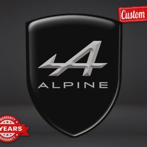 May include: A black shield-shaped emblem featuring the silver Alpine logo and the word ALPINE in capital letters. The image includes a red rectangular tag with the text Custom Made and a red circular badge with the text 5 YEARS WARRANTY.