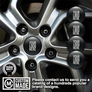 May include: A silver car wheel rim featuring a central circular emblem with a black background, a subtle hexagonal pattern, and the white text YOUR LOGO HERE. Four additional identical circular emblems are stacked vertically on the right side.