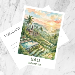 Peut inclure: Une carte postale présentant une illustration à l'aquarelle d'un paysage de Bali avec des rizières en terrasses, des palmiers, une piscine et une architecture traditionnelle sous un ciel au coucher du soleil. Le texte POSTCARD et BALI INDONESIA figurent.