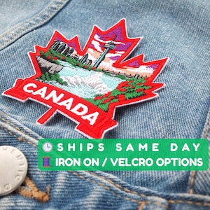 以下が含まれることがあります： 「CANADA」の文字が入った赤いカエデの葉の刺繍パッチ。パッチは滝、建物、塔のある風景デザインが特徴です。パッチはアイロン接着式で、デニムジャケットに取り付けられています。