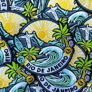 Puede incluir: Parches bordados con un diseño de Río de Janeiro. Los parches muestran un sol amarillo, palmeras, olas del océano y la estatua del Cristo Redentor. También se incluye el texto "RIO DE JANEIRO".