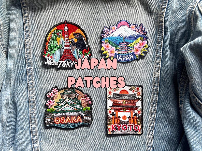 Puede incluir: Cuatro parches bordados con monumentos y ciudades japonesas. Los parches incluyen im&aacute;genes de Godzilla y la Torre de Tokio, el Monte Fuji, el Castillo de Osaka y un templo de Kioto. El texto "TOKY JAPAN PATCHES" est&aacute; escrito en blanco y rosa.