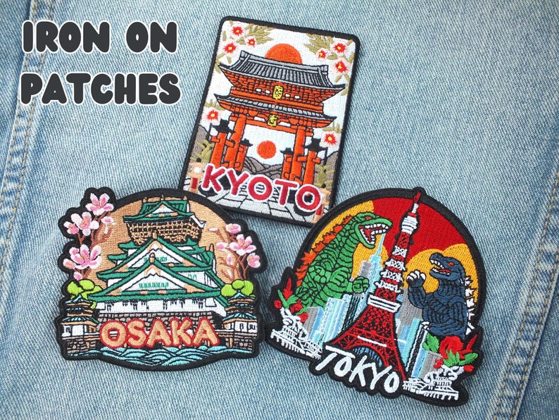 Puede incluir: Parches bordados para planchar con monumentos japoneses e iconos de la cultura pop. Los dise&ntilde;os incluyen un templo de Kioto, el castillo de Osaka y Godzilla con la Torre de Tokio. El texto "IRON ON PATCHES" est&aacute; en la parte superior.