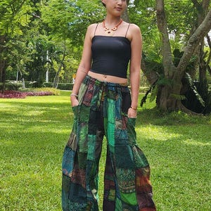 May include: Green, blue, and brown patchwork pants with a drawstring waist. The pants are wide-legged and have a relaxed fit.