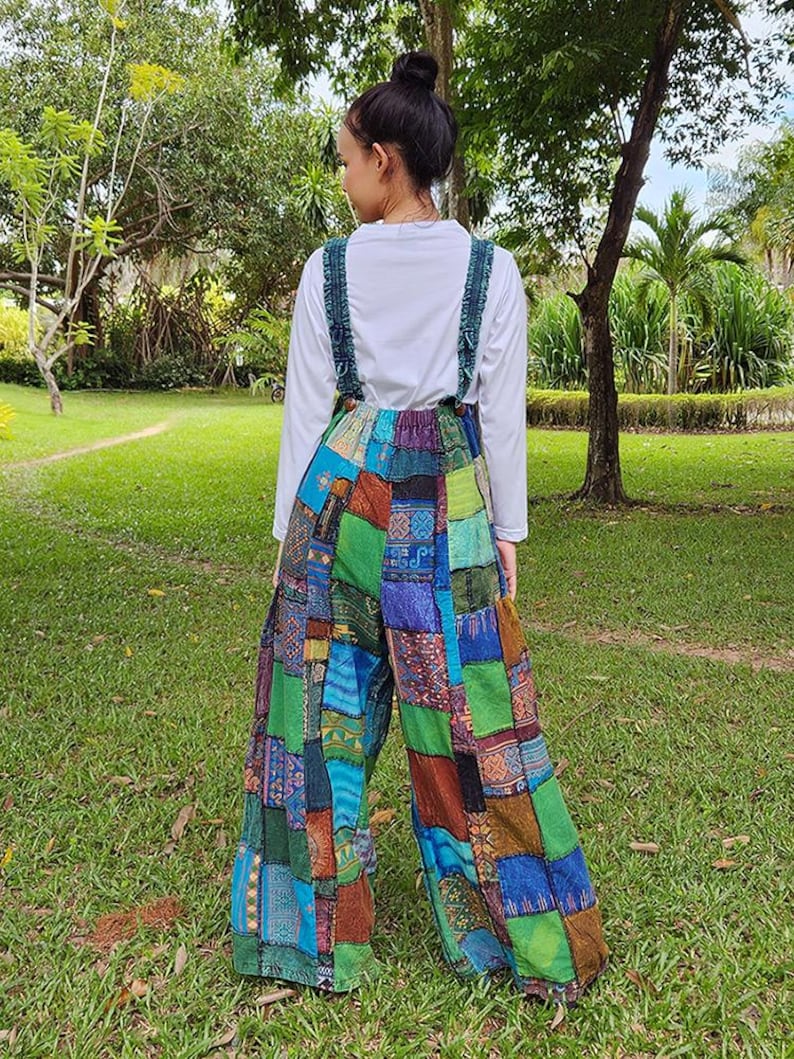 May include: Patchwork wide-leg overalls with a colorful, multi-patterned design. The overalls have adjustable straps and a relaxed fit.