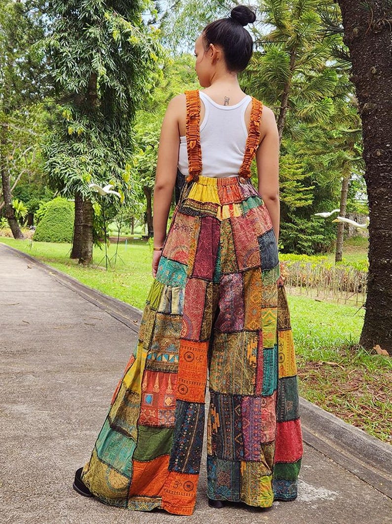 May include: A pair of wide-leg patchwork pants with a colorful, multi-patterned design. The pants have a high waist and are made from a variety of fabrics, including cotton and silk. The pants are a vibrant mix of colors, including red, orange, yellow, green, blue, and purple.