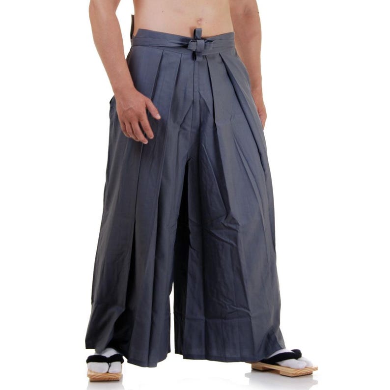 May include: A pair of grey wide-legged trousers with a pleated front and a tied waistband.