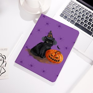 May include: A purple notebook with a Halloween theme. The cover shows a black cat in a witch's hat, an orange jack-o'-lantern, and a small bat. The background is decorated with spider illustrations.