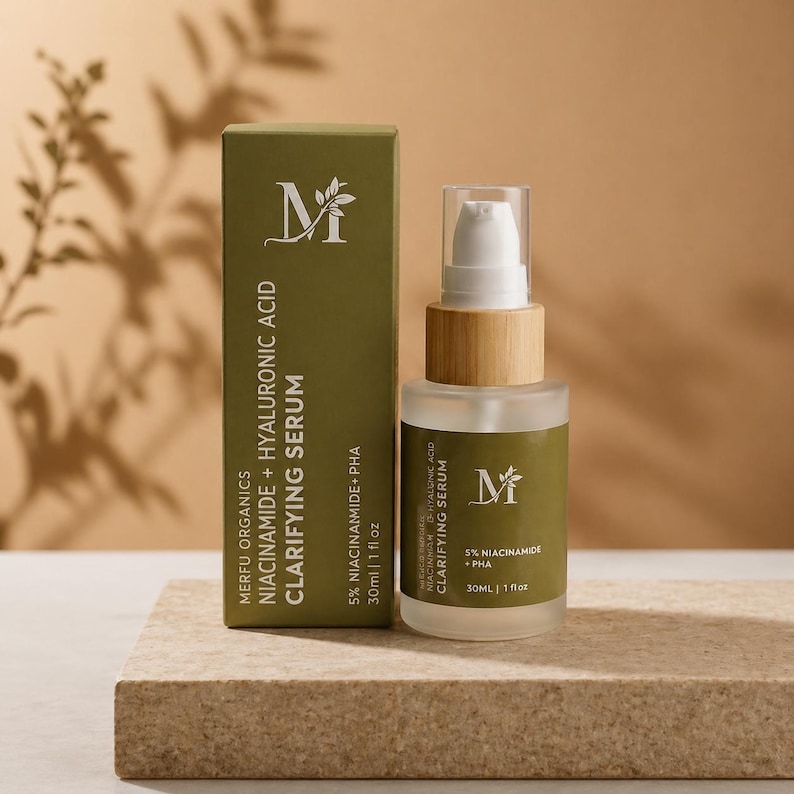 May include: A skincare product set with a green box and a clear glass bottle. The box and bottle display the text "MERFU ORGANICS CLARIFYING SERUM" with the ingredients listed. The bottle has a wooden cap and a white pump.