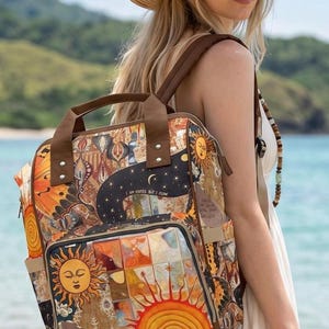 Puede incluir: Una mochila con un estampado celestial vibrante y multicolor que incluye soles, lunas y patrones abstractos. La bolsa cuenta con asas superiores marrones, correas ajustables para los hombros, un bolsillo frontal con cremallera y bolsillos laterales.