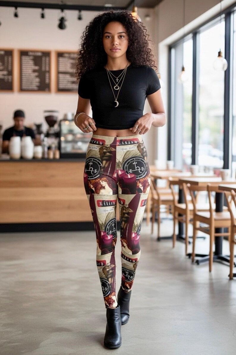 May include: High-waisted leggings featuring a repeating graphic print of the word Lilith, dark red candles, and circular occult-style sigils on a beige background. The leggings are paired with a plain black short-sleeved crop top and black boots.
