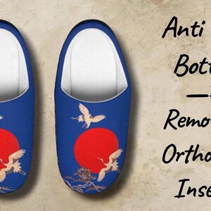 May include: A pair of blue slippers with a red sun and crane design. The slippers have white interiors and feature the text "Anti Skid Bottom, Removable Orthopedic Inserts."