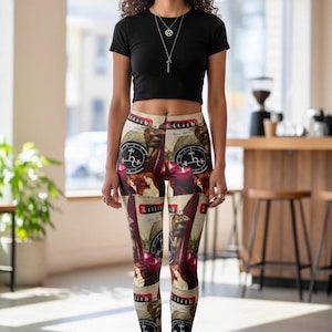 May include: A black short-sleeved crop top and leggings featuring a repeating collage print. The leggings display images of a woman with long red hair, red candles, and circular black symbols with white text reading Lilith and other markings.