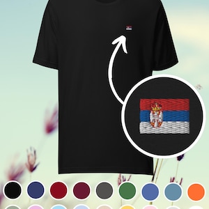Pode incluir: Camiseta preta com uma pequena bandeira sérvia bordada no peito. A bandeira apresenta listras horizontais vermelhas, azuis e brancas com o brasão sérvio. Uma seleção de opções de cores é exibida.
