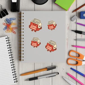 K&ouml;nnte beinhalten: Vier Aufkleber mit einem Cartoon-Design eines rot-wei&szlig;en K&uuml;hlers mit dem Text "DON'T HATE ME BECAUSE I'M A Little Cooler". Die Aufkleber befinden sich auf einem grauen Notizbuch, umgeben von B&uuml;robedarf.