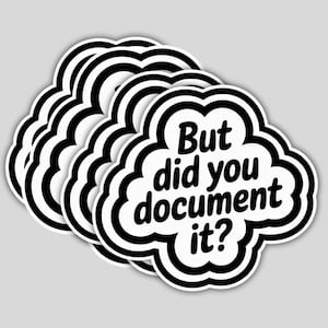 May include: A stack of white cloud-shaped stickers with a black border. The stickers have the text "But did you document it?" in a bold, black font. The stickers are on a light gray background.