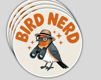 May include: A stack of round stickers featuring a cartoon bird wearing a hat and glasses, holding binoculars. The text "BIRD NERD" is in orange letters around the bird. The bird has orange, gray, and white feathers.