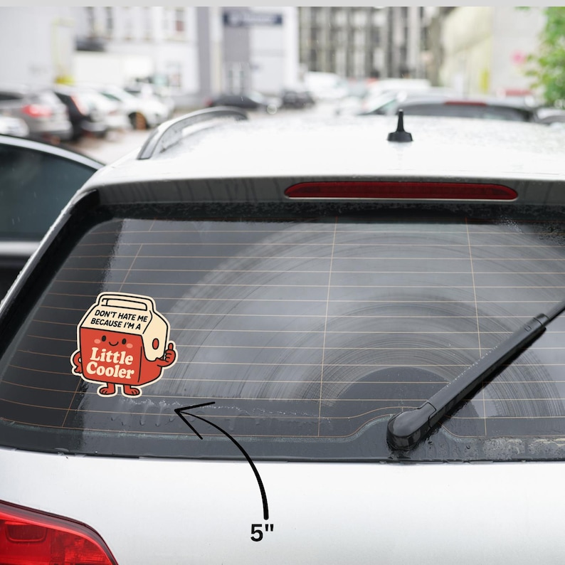 K&ouml;nnte beinhalten: Ein 12,7 cm gro&szlig;er Aufkleber mit einem Cartoon-K&uuml;hler mit dem Text "DON'T HATE ME BECAUSE I'M A Little Cooler". Der K&uuml;hler ist rot mit einem l&auml;chelnden Gesicht und einem Daumen hoch. Der Aufkleber befindet sich auf einem Auto.