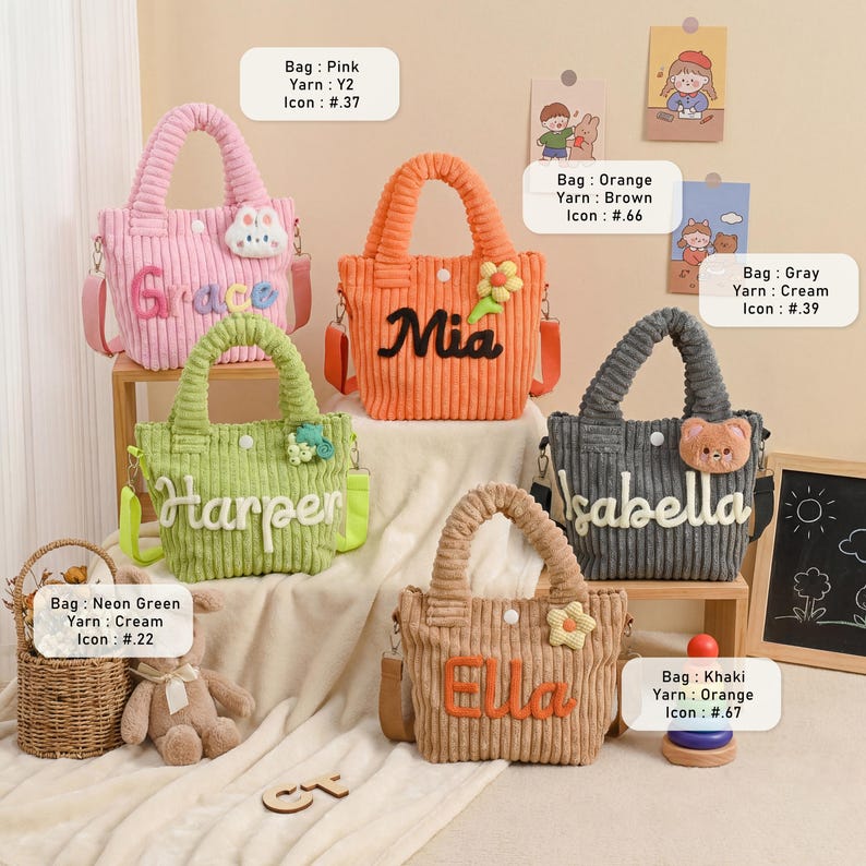May include: A collection of corduroy tote bags in various colors, including pink, orange, green, gray, and khaki. Each bag features a name embroidered on the front and a matching shoulder strap. Some bags have decorative accents.