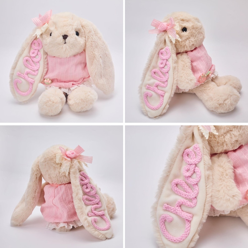 K&ouml;nnte beinhalten: Ein beiges Pl&uuml;schhasen-Stofftier mit langen Ohren, das ein rosa strukturiertes Oberteil und einen wei&szlig;en Spitzenbesatz tr&auml;gt. Auf einem Ohr ist der Name Chloe in rosa Garn gestickt. Eine kleine rosa Schleife ist am Kopf des Hasen befestigt.