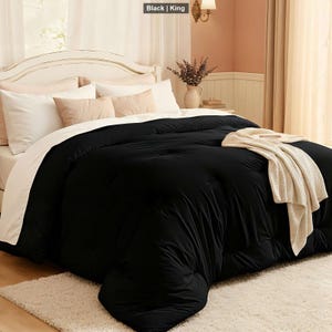 May include: A black king-size comforter on a bed with white and beige pillows. A cream-colored throw blanket is draped over the comforter. The text "Black | King" is in the top left corner.