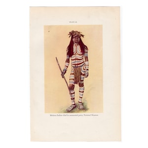 May include: A Mohave Indian chief in ceremonial paint, standing with a staff. The image is from the National Museum.