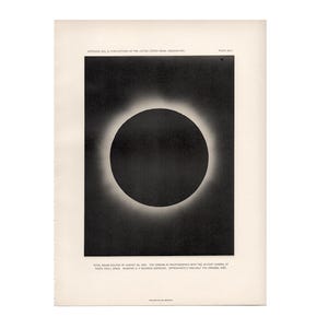 Könnte beinhalten: Ein Vintage-Druck, der eine totale Sonnenfinsternis darstellt. Das Bild zeigt eine dunkle, kreisförmige Finsternis mit einer hellen Korona. Der Druck befindet sich auf gealtertem Papier und enthält Text oben und unten, der seinen Ursprung vom United States Naval Observatory angibt.