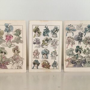 Puede incluir: Tres ilustraciones vintage de mujeres con sombreros elaborados. Las ilustraciones son en blanco y negro con acentos de color pintados a mano. Los sombreros est&aacute;n decorados con flores, cintas y plumas.