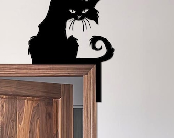 May include: A black metal cat silhouette perched on a wooden door frame. The cat has a stern expression, with pointed ears and a curled tail. The cat's silhouette is a decorative accent for a door or wall.