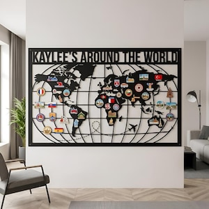 May include: Black metal world map wall art with the text "KAYLEE'S AROUND THE WORLD". The map features a grid and various colorful travel-themed pins. A decorative piece for travel enthusiasts.