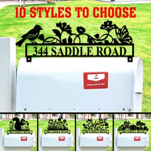 May include: A black metal address sign with the text "344 SADDLE ROAD" and decorative cutouts of a bird, flowers, and a butterfly. The sign is mounted above a white mailbox. The image also shows other design options.