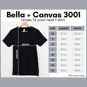 May include: A black Bella + Canvas 3001 unisex crew neck t-shirt displayed on a wooden hanger. The image includes a size chart with measurements in inches, ranging from XS to 4X, detailing length and width.
