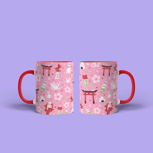 May include: Two pink ceramic mugs with red handles. Both mugs feature a repeating pattern of Japanese cultural icons, including cherry blossoms, red gates, and origami cranes.