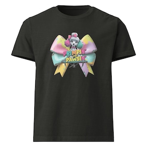 May include: Black t-shirt featuring a colorful bow design with a poodle illustration. The bow is pastel-colored with the text "PRIMPIN' and PAWSIN'" in a playful font. The poodle has pink and teal accents.