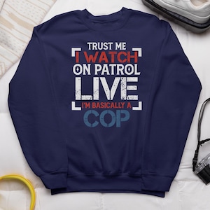 May include: Navy blue sweatshirt with a white graphic that says "Trust me I watch on patrol live I'm basically a cop".