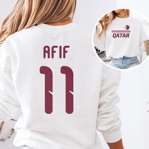 a person wearing a white sweatshirt with the number 11 and the name 'AFIF' printed on the back.