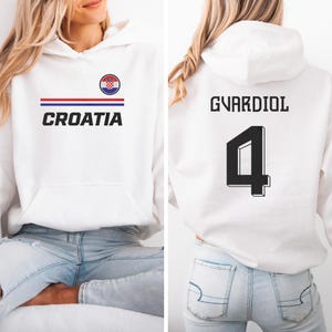 A white hoodie with the word "CROATIA" printed on it, along with a Croatia flag design. The back of the hoodie has the name "GVARDIOL" and the number "4" printed on it.