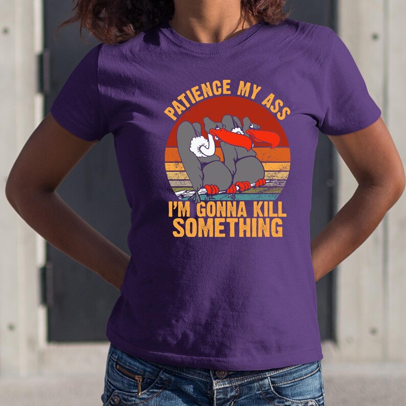 a woman wearing a purple t - shirt that says i'm going to kill