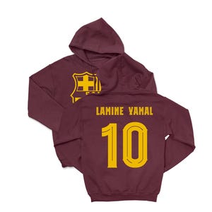 A maroon hoodie with a yellow logo and the name 'LAMINE YAMAL' printed on the back, along with the number '10'.