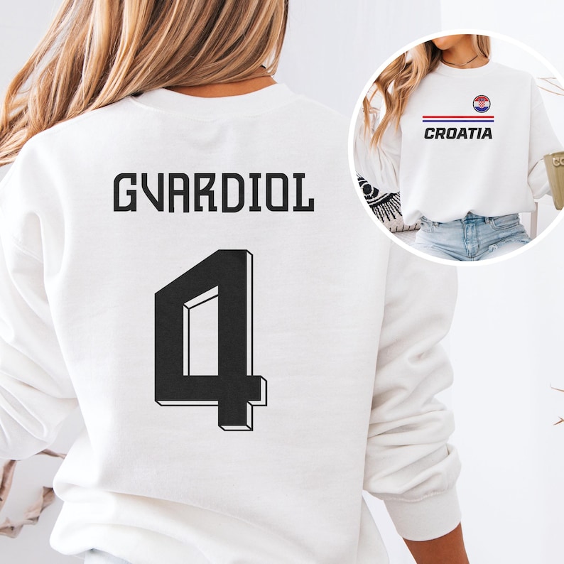 A white sweatshirt with the name 'GVARDIOL' and the number '4' printed on the back, along with a graphic of a flag.